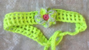 Gehäkeltes Stirnband in hellgrüner Baumwolle mit Blume